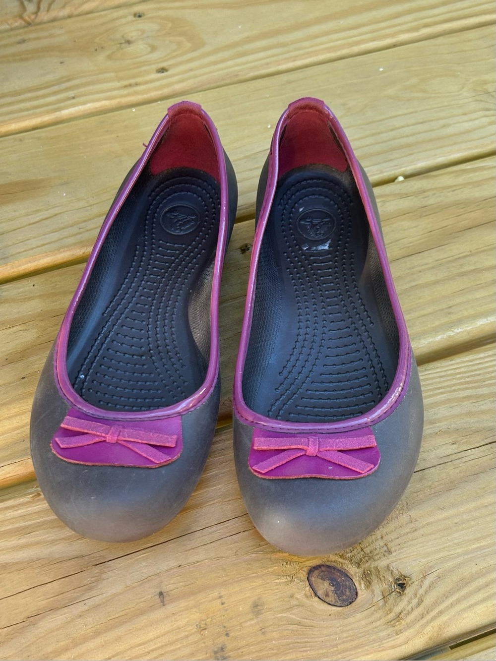 CROCS Brown Flats with Pink Trim and Bow Accent